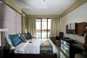 a bedroom with a bed and a desk and a television at Kuta Luxury Residence in Kuta