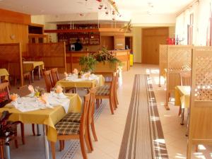 Hotel Vrsatec في Vršatské Podhradie: مطعم بطاولات وكراسي صفراء ومطبخ