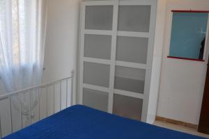 1 dormitorio con una puerta corredera en el armario y 1 cama en Residence Mare Blu en Lampedusa