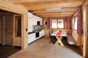 eine Küche mit einem Tisch und einer Bank in einer Hütte in der Unterkunft Ferienhütten Lechtal Chalets in Elbigenalp