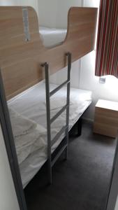 a bunk bed in a room with a ladder on it at Camping de la minière in Forges-les-Eaux