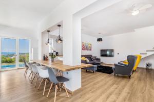 uma cozinha e sala de estar com mesa de jantar e cadeiras em Villa Krasica em Krasica