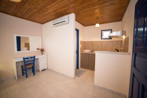 a kitchen with a table and a blue chair in a room at Sunset Hotel in Agios Ioannis Kaspaka
