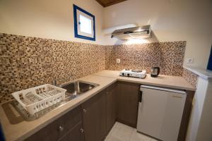 a small kitchen with a sink and a dishwasher at Sunset Hotel in Agios Ioannis Kaspaka