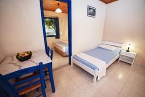 a bedroom with a bed and a table and a mirror at Sunset Hotel in Agios Ioannis Kaspaka