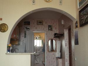 an archway in a kitchen with a sink and a mirror at Krāslava City Apartment in Krāslava
