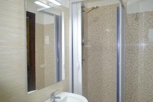 a bathroom with a sink and a shower with a mirror at B&B Lungomare in Catania