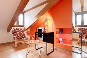 トリノにあるApartment Bijouxのオレンジ色の客室で、デスクと椅子が備わります。