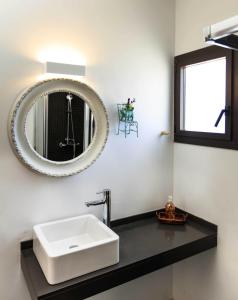 Un baño con un lavabo blanco y un espejo. en Can Coques, en Sant Francesc Xavier 22 fotos más