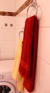 een badkamer met rode en gele handdoeken op een handdoekenrek bij Apartment Dore in Krk
