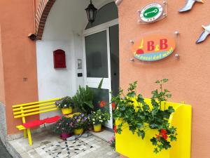 a yellow bench in front of a building with flowers at Due Passi dal Mare in Ceriale