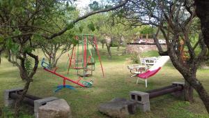 a park with a swing set and a playground at La Alquimia Casas de Campo in La Granja