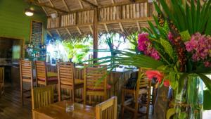 un restaurant avec des tables, des chaises et un vase de fleurs dans l'établissement The Hummingbird, à Bocas del Toro