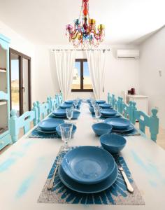 una mesa larga con placas azules y cubiertos en Can Coques en Sant Francesc Xavier