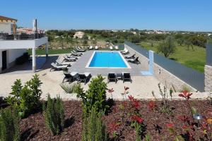 a swimming pool with chaise lounges and lounge chairs at Sunfield Guest House - Only Adults in Albufeira