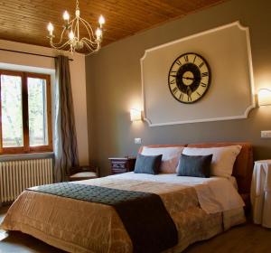 1 dormitorio con 1 cama grande y reloj en la pared en Suite Umberto I en Assisi