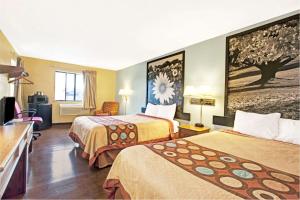 a hotel room with two beds and a television at Super 8 by Wyndham Baltimore/Essex Area in Essex