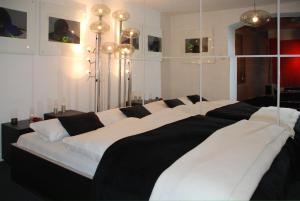 a large bed with black and white sheets in a room at Artist Residence Schwabing in Munich