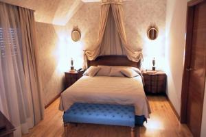 sypialnia z łóżkiem z niebieską ławką w obiekcie Hotel Santiago w mieście Benavente