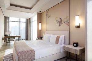 um quarto com uma grande cama branca e uma secretária em Grand Mayfull Taipei em Taipei