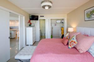 a bedroom with a large bed with a pink blanket at Florence in South Padre Island