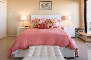 a bedroom with a large pink bed with pillows at Florence in South Padre Island