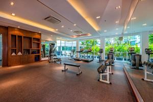 a gym with treadmills and exercise equipment in a building at Fishermens Harbour Urban Resort - SHA Extra Plus in Patong Beach