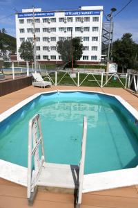 a swimming pool with a chair in front of a building at Hotel Complex Vostok in Vrangel'