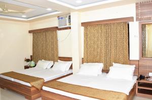 twee bedden in een kamer met ramen bij HOTEL ATA INN AND RESTAURANT (20 Mtrs from Dargah), Ajmer in Ajmer