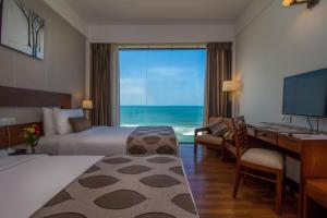 a hotel room with a bedroom with a view of the ocean at The Ocean Colombo in Colombo