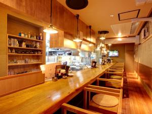 a bar with a long wooden counter in a restaurant at Hotel Roco Inn Okinawa in Naha