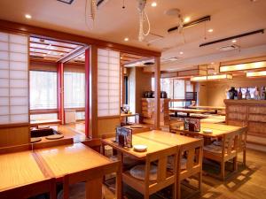 a restaurant with wooden tables and chairs and windows at Hotel Roco Inn Okinawa in Naha