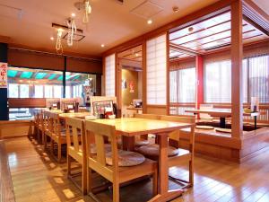 a restaurant with wooden tables and chairs and windows at Hotel Roco Inn Okinawa in Naha