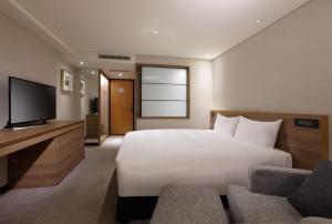 um quarto de hotel com uma cama e uma televisão de ecrã plano em Royal Inn Taipei Nanxi - MRT Zhongshan Station em Taipei