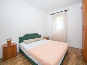 een slaapkamer met een groen bed en een raam bij Apartment Mile in Petrovac na Moru