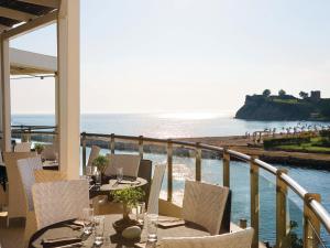balcone con tavoli, sedie e vista sulla spiaggia di Mira Forest Residences a Sani Beach