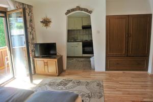 ein Wohnzimmer mit einem TV und einer Küche in der Unterkunft Haus Stratton in Innsbruck