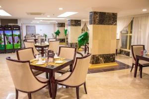 a dining room with tables and chairs in a restaurant at Alazhar Palace Hotel in Al Qunfudhah +43 photos