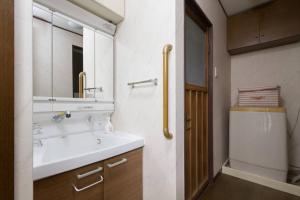 a bathroom with a sink and a mirror at Osaka Nakayama Guesthouse in Osaka