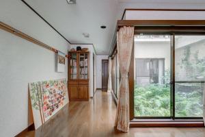 a hallway with a large window and a door at Osaka Nakayama Guesthouse in Osaka