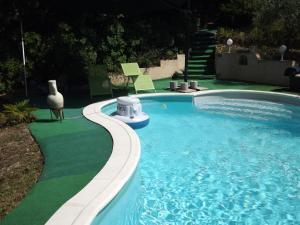 a swimming pool in a yard with a green lawn at Gite des vallées d'Azur in Puget-Théniers