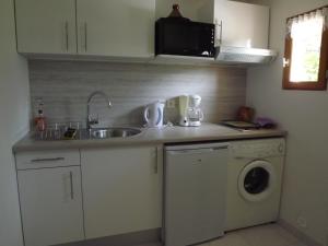 a kitchen with a sink and a washing machine at Gite des vallées d'Azur in Puget-Théniers +2 photos