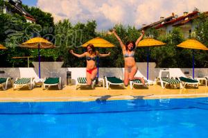 two women in bathing suits jumping into a swimming pool at Hotel Seril 2 in Fethiye