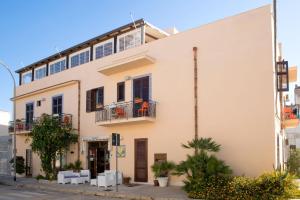 un gran edificio blanco en una calle de la ciudad en Agave Superior Rooms, en San Vito lo Capo