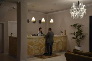 Een man aan een bar in een lobby. bij Hotel Turizem Shkelzeni in Kolgecaj