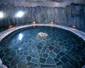 a pool of water with a rock wall at SPA&HOTEL RESORT Furano La Terre in Nakafurano +77 photos