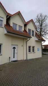 ein großes weißes Haus mit einer Ziegelsteinfahrt in der Unterkunft Kirchseeblick 5&6 in Kirchdorf