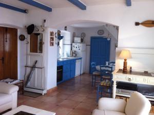a kitchen with blue cabinets and a blue door at indé no in Sari Solenzara