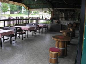 un restaurant avec des tables et des tabourets dans une pièce dans l'établissement Guesthouse Zeko, à Aljmaš