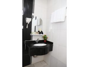 a bathroom with a black sink and a mirror at Al Hussam Hotel Apartments in Muscat